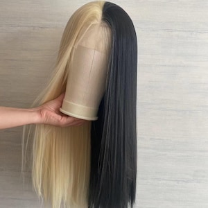 May include: A long, straight wig with half blonde and half black hair. The wig is on a mannequin head.
