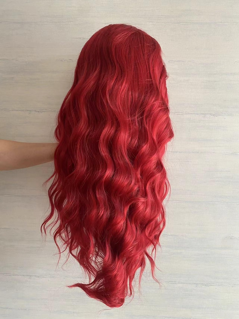 Puede incluir: Una peluca larga y ondulada de color rojo brillante. La peluca est&aacute; peinada en ondas sueltas y tiene un acabado de aspecto natural.