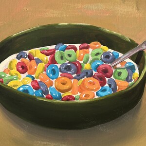 May include: A green bowl filled with colorful cereal rings and milk. A silver spoon is in the bowl.