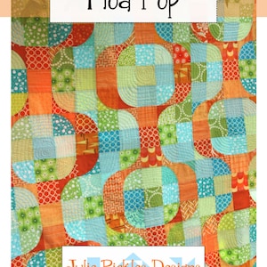 May include: A colorful quilt with a patchwork design featuring circles and squares in shades of orange, green, blue, and white. The quilt is titled "Mod Pop" and is by Julie Pickles Designs.