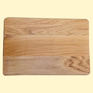May include: A rectangular wooden chopping board with a natural wood grain finish. The board is made of light brown wood and has a smooth surface.