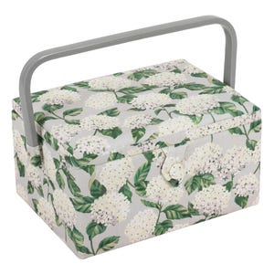 May include: A rectangular sewing box with a grey handle and a floral pattern. The box is covered in a light grey fabric with a pattern of white hydrangea flowers and green leaves. A grey button secures the lid.