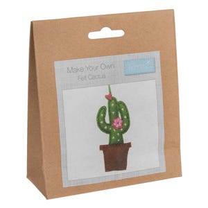 Könnte beinhalten: Eine braune Papiertüte mit einem ausgestanzten Griff enthält ein Bastelset. Das Set zeigt ein Filz-Kaktus-Design mit dem Text "Make Your Own Felt Cactus". Der Kaktus ist grün mit einer rosa Blume und sitzt in einem braunen Topf.