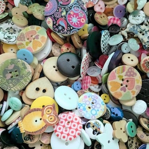 May include: A selection of assorted buttons in diverse shapes, sizes, and colours. The buttons feature round, oval, and novelty forms, with designs like hearts, owls, and floral patterns. Some are plain, while others have multiple holes for sewing.