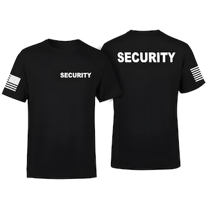 May include: A black short-sleeved t-shirt featuring the word SECURITY in white text on the front left chest and across the upper back. The right sleeve displays a white graphic of the American flag, while the left sleeve shows a white flag design.