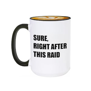 Könnte beinhalten: Weiße Keramik-Kaffeetasse mit schwarzem Henkel. Die Tasse hat einen schwarzen Text mit der Aufschrift "SURE, RIGHT AFTER THIS RAID".