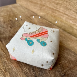 Poduszka do rolek: Pojemnik na igły do szycia wypełniony kruszonym orzechem włoskim