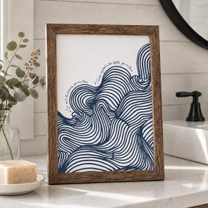 May include: A rectangular wooden frame containing a white print with dark blue wavy line patterns. The print features cursive text that reads, If I go up to the heavens, you are there. If I make my bed in the depths, you are there.