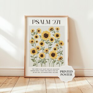 May include: A framed vertical poster featuring a light gray background with a cluster of yellow sunflowers and green stems. The text PSALM 27:1 appears at the top, and the full verse is printed in black capital letters at the bottom of the print.