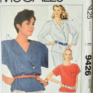 Puede incluir: Un patrón de costura para dos blusas. La primera blusa es una blusa azul de doble botonadura con cuello en V y cinturón. La segunda blusa es una blusa roja de manga corta con un bolsillo. El patrón es McCall's 9426, talla 10, y cuesta $ 4.25.
