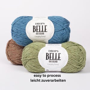May include: Three skeins of Drops Belle yarn in blue, green, and brown. Each skein has a white label with the text "DROPS BELLE UNI COLOUR Everyday luxury!" and the words "easy to process leicht zuverarbeiten" at the bottom.