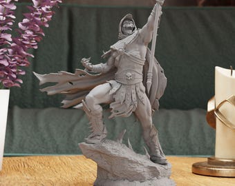 Puede incluir: Una figura gris impresa en 3D de un guerrero sosteniendo un bastón, de pie sobre una base rocosa. El guerrero lleva armadura y una capa.