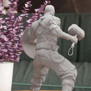 a statue of a man holding a pair of dumbs