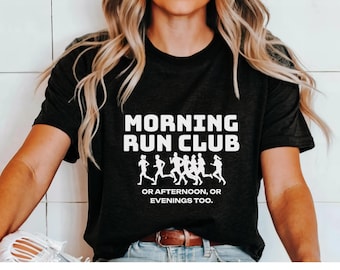 Puede incluir: Camiseta negra con texto blanco que dice "Morning Run Club or Afternoon, or Evenings Too." El texto está rodeado por un grupo de figuras corriendo.