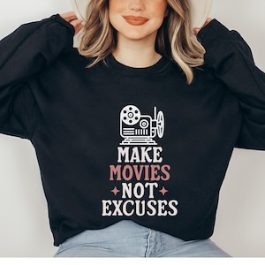 May include: Black sweatshirt with a white graphic of a film camera and the text "Make Movies Not Excuses" in white with "Movies" in pink.