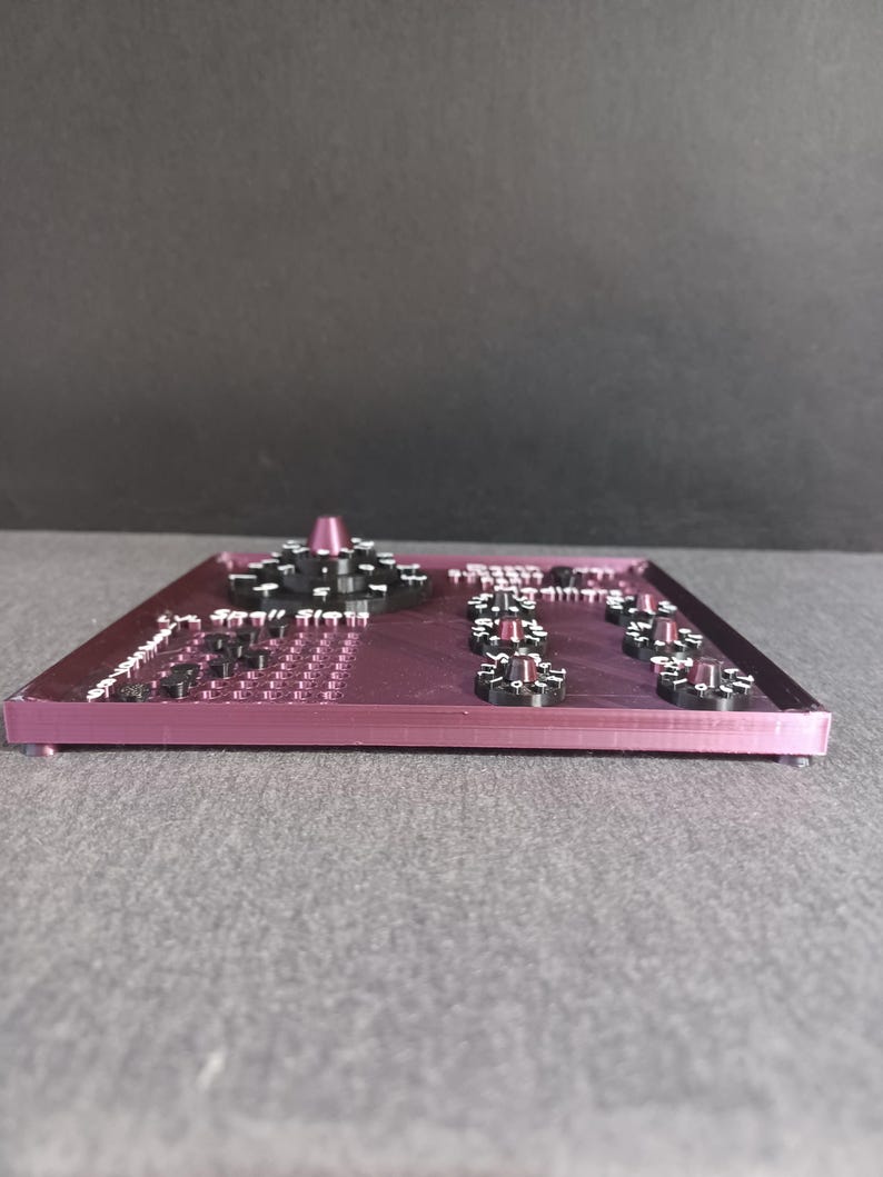 May include: A purple plastic panel with multiple black knobs and a white dial. The panel has a grid of small holes and the text "Sequill Sleep" printed on it.