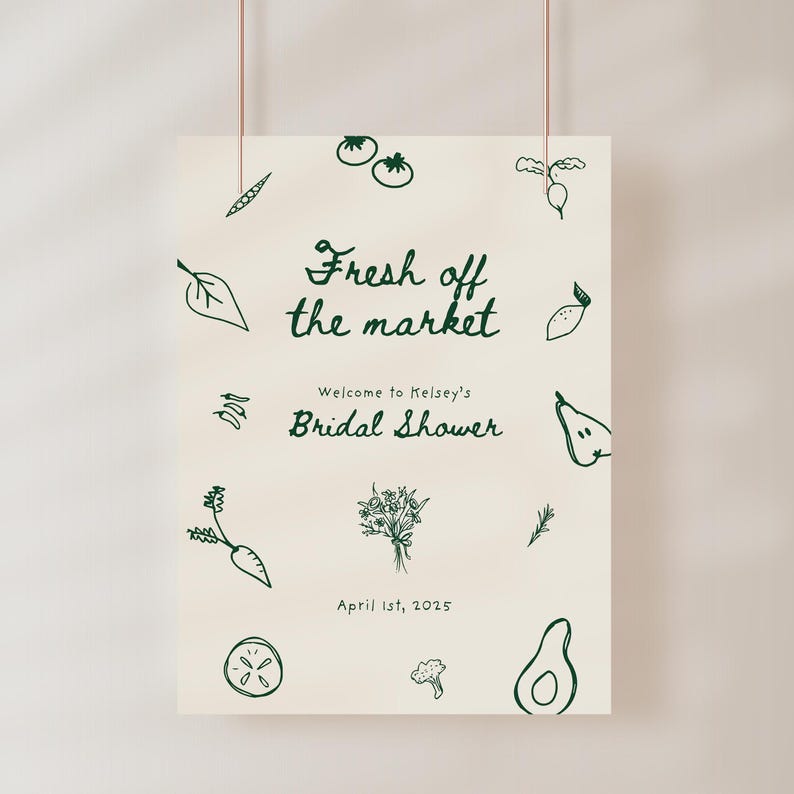 May include: A white sign with green illustrations of vegetables and fruits. The text reads "Fresh off the market" and "Welcome to Kelsey's Bridal Shower" with the date "April 1st, 2025".