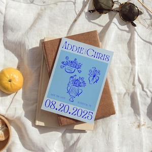 May include: Blue and white save the date card with the text "Addie & Chris" and "08.20.2025" with a floral design.