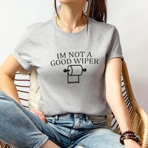 May include: A gray t-shirt with the text "I'm not a good wiper" and a black and white illustration of a toilet paper roll.