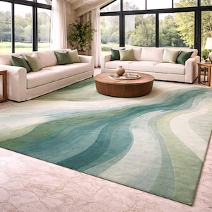 May include: A large rectangular area rug featuring a flowing, wave-like pattern in various shades of green, teal, and cream. The design consists of smooth, undulating bands of color that transition across the surface, creating a fluid visual effect.
