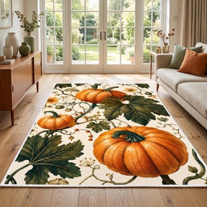 May include: A rectangular area rug featuring a cream-colored background with a repeating botanical pattern of large orange pumpkins, dark green lobed leaves, thin winding vines, and small clusters of red berries spread across the surface.
