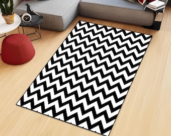 May include: A rectangular area rug featuring a high-contrast black and white chevron pattern. The design consists of repeating zigzag lines that span the entire surface of the rug, creating a bold geometric visual effect across the floor.