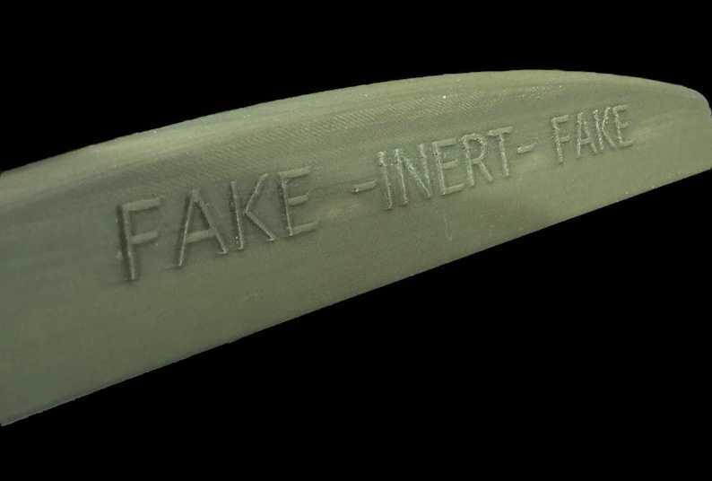 Close-up novelty prop marking reading FAKE INERT FAKE