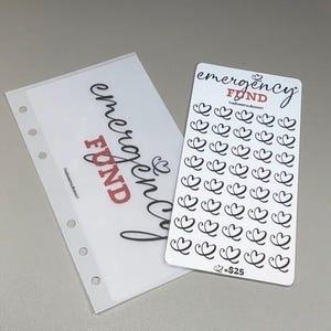 May include: A translucent plastic binder insert with five holes and a white card featuring the text emergency FUND and a grid of 35 black heart icons. The card includes the text THEKAREFULBUDGET and the notation heart equals $25 at the bottom.