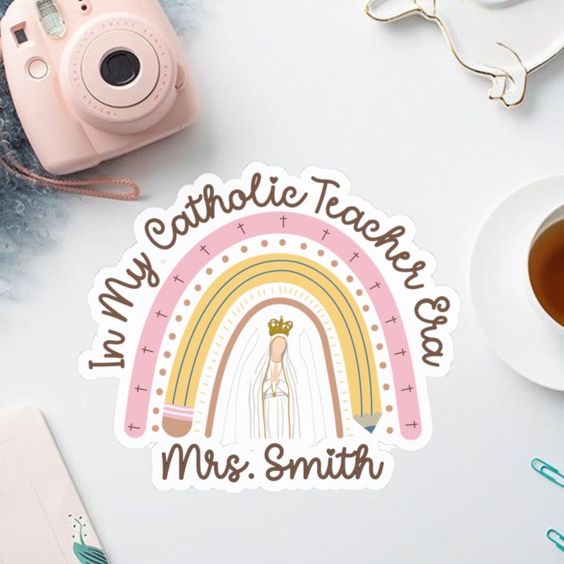 May include: A sticker with a rainbow design and the text "In My Catholic Teacher Era" and "Mrs. Smith". The rainbow has pink, yellow, and white colors. A drawing of a religious figure is in the center.