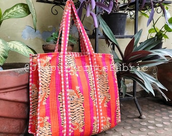 Könnte beinhalten: Eine lebendige Tragetasche mit Tigerdruck. Die Tasche hat ein sich wiederholendes Muster aus orangefarbenen Tigern auf einem gestreiften rosa-orangenen Hintergrund. Die Griffe sind rosa und weiß gestreift. Der Text "@JaipurPrintsFabric" ist auf der Seite der Tasche zu sehen.