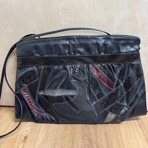 May include: A black leather shoulder bag with a snakeskin pattern. The bag has a flap closure and a long strap.