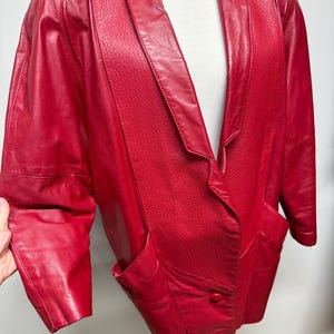 Veste en cuir rouge vintage des années 80, tout début des années 90, avec des détails en cuir texturé, des épaules surdimensionnées et de grandes poches