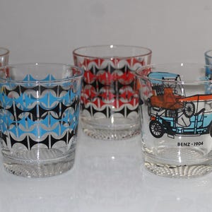 May include: Set of five vintage glass tumblers with a geometric pattern and a different vintage car design on each. The cars are in red, blue, and yellow.