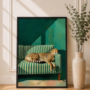 May include: A framed wall art print featuring a cheetah resting on a green and white striped sofa. The artwork displays a deep green wall background with sharp shadows and a textured paint effect. The print is enclosed in a thin black frame.