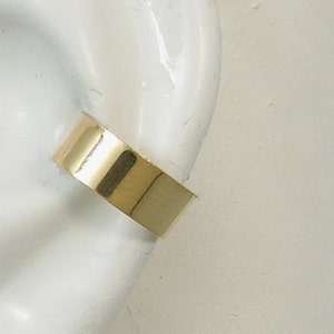 May include: A gold ear cuff, a simple and elegant piece of jewelry.