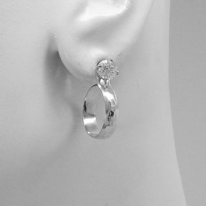May include: Silver hoop earrings with a hammered finish and a clear round stone.