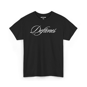 Pode incluir: Camiseta preta com a palavra "Deftones" em branco, com uma fonte cursiva na frente. A camiseta tem mangas curtas e gola redonda. O nome da marca "Deftones" é impresso em letras brancas pequenas na parte superior.