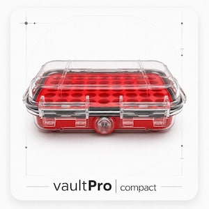 May include: A clear, rectangular storage case with a red interior insert featuring multiple circular cutouts. The case has a secure latch mechanism and a central circular pressure valve. The text "vaultPro | compact" is printed below the case.