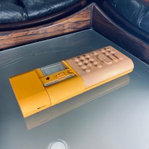 May include: A yellow and beige vintage calculator with a digital display and a slide switch labelled "minus, div, plus, max 18".