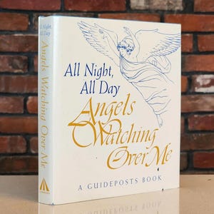 Peut inclure: Un livre à couverture rigide crème intitulé "All Night, All Day Angels Watching Over Me". La couverture présente une illustration d'ange en bleu et or. Il s'agit d'une publication Guideposts.