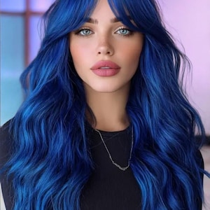 May include: A person with long, wavy, vibrant blue hair featuring curtain bangs. The hair color is a deep, saturated electric blue shade. The individual has light skin, light blue eyes, and is wearing a simple black long-sleeved top with a thin silver chain necklace.