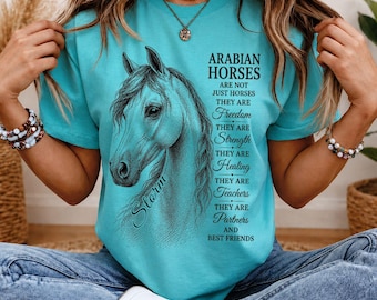 Puede incluir: Una camiseta turquesa de manga corta con una ilustración detallada de la cabeza de un caballo árabe y el texto: ARABIAN HORSES ARE NOT JUST HORSES THEY ARE Freedom THEY ARE Strength THEY ARE Healing THEY ARE Teachers THEY ARE Partners AND BEST FRIENDS.