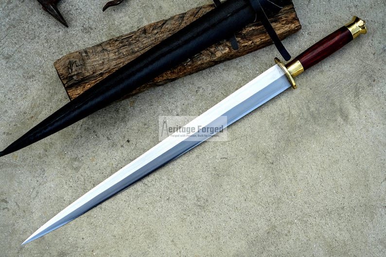 May include: A long, silver blade sword with a dark wood handle and gold accents. The sword is displayed with a black sheath and rests on a wooden plank. The text "Aeritage Forged" is visible on the blade.