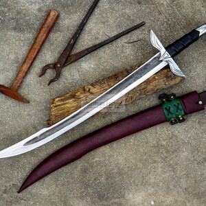 May include: A silver sword with a black handle and a burgundy sheath, resting on a piece of wood. A hammer and pliers are also visible, suggesting a blacksmithing theme.