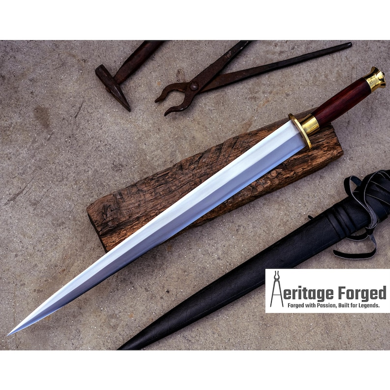 May include: A polished steel dagger with a dark wood handle and gold accents rests on a wooden block. A black leather sheath and blacksmith tools are nearby. The text "Aeritage Forged" is visible.