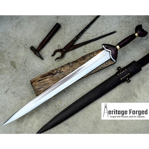 May include: A silver sword with a dark wood handle and a black leather scabbard. The sword is resting on a wooden block. The image also includes a hammer and a pair of pliers.