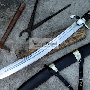 May include: A large, curved sword with a silver blade and black handle, resting on a wooden plank. A black sheath with gold accents and leather straps is next to the sword. Additional tools, including a hammer and pliers, are also present.