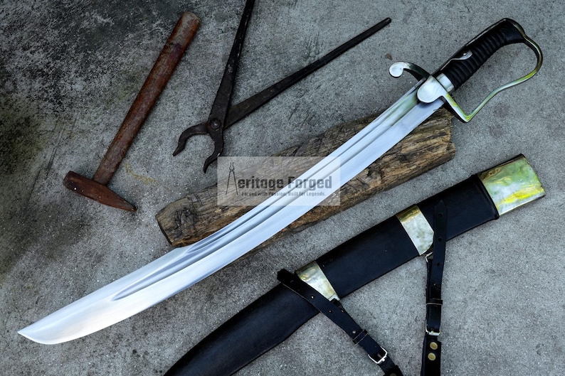 May include: A large, curved sword with a silver blade and black handle, resting on a wooden plank. A black sheath with gold accents and leather straps is next to the sword. Additional tools, including a hammer and pliers, are also present.