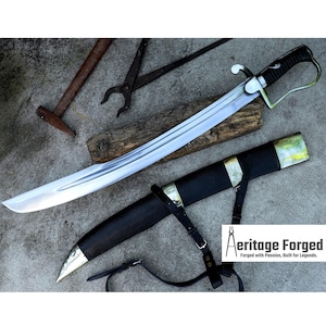 May include: A polished steel saber with a curved blade, black handle, and silver accents, resting in a black leather sheath with a silver tip. The image also shows a hammer, tongs, and the text "Aeritage Forged".