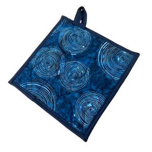 May include: Blue and white patterned pot holder with a dark blue border. The pattern features a repeating design of white circles with concentric rings.